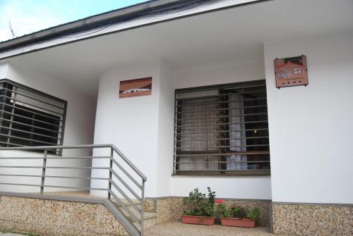 a white building with two windows and a staircase at Casa rural Puente Mocho in Ledesma
