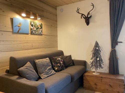 a living room with a couch and a deer head on the wall at Au charmant chablis in Champagnole