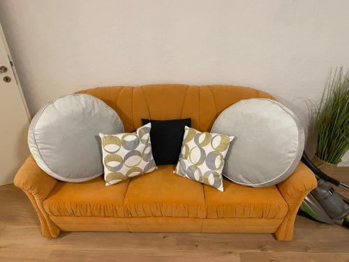 a couch with three pillows on it at Gemütliche Unterkunft 3-Raum in Hoyerswerda