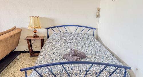 une chambre avec un lit bleu avec un oreiller et une lampe dans l'établissement La Caze - Idéal couple de curistes - 40 m2, à Balaruc-les-Bains
