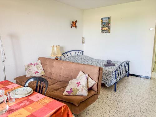 - un salon avec un canapé et un lit bébé dans l'établissement La Caze - Idéal couple de curistes - 40 m2, à Balaruc-les-Bains