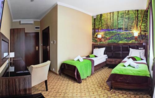 ein Hotelzimmer mit 2 Betten und einem Gemälde an der Wand in der Unterkunft Podgrodzie in Kowal