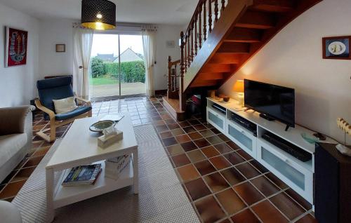ein Wohnzimmer mit einer Couch und einem Fernseher und Treppen in der Unterkunft Nice Home In Plouguerneau With Wifi in Plouguerneau