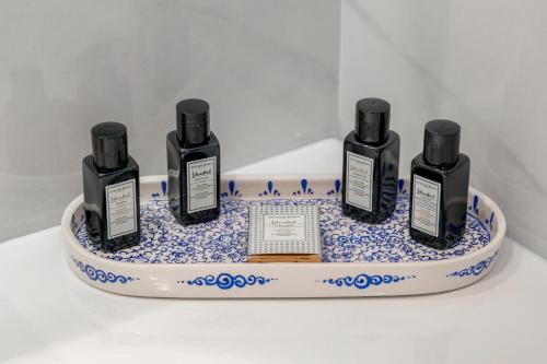 three bottles of essential oils on a blue and white plate at Mula Hotel in Istanbul
