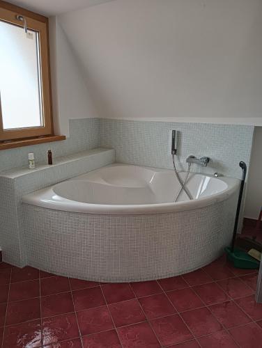 a white bath tub in a bathroom with a window at Mansarda Open Space in Ciampino