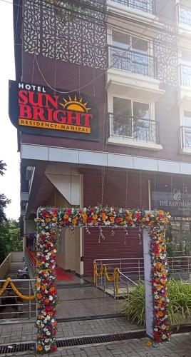 a building with a sign for a sun bright restaurant at Hotel Sun Bright Residency Manipal in Manipala