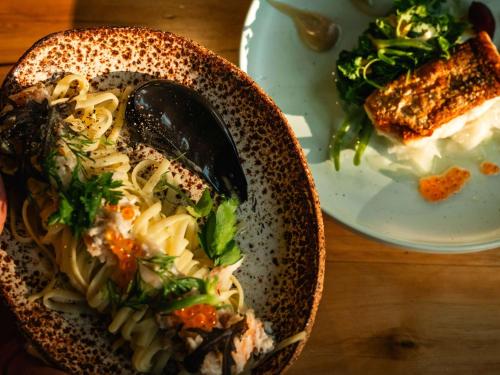 a bowl of pasta and a plate of food at Cooinda Lodge Kakadu in Jabiru