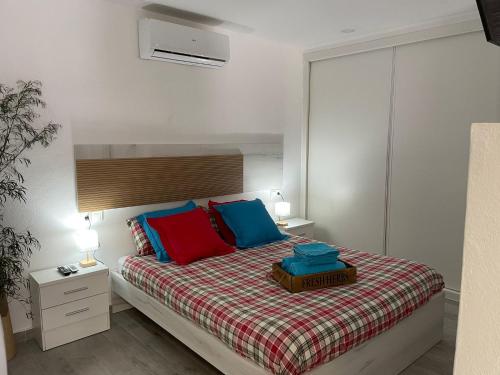 a bedroom with a bed with red and blue pillows at El rincon de Mauro in Altea