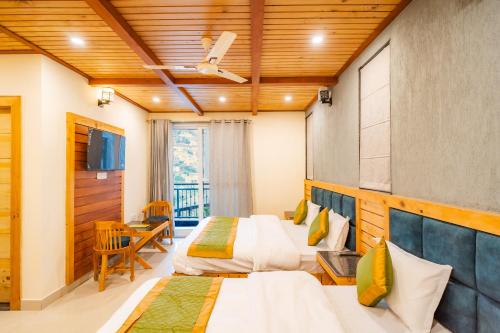 a hotel room with two beds and a tv at Winterfell Stays Mussoorie in Mussoorie