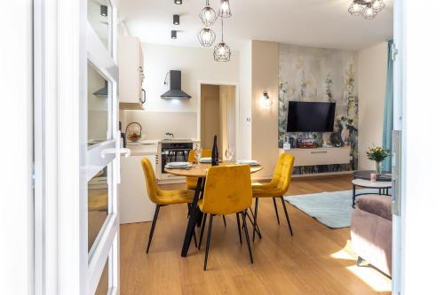 a dining room and living room with a table and chairs at Nemes Apartment The Great - Petite in Nemesvita