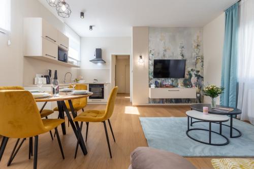 a kitchen and living room with a table and chairs at Nemes Apartment The Great - Petite in Nemesvita