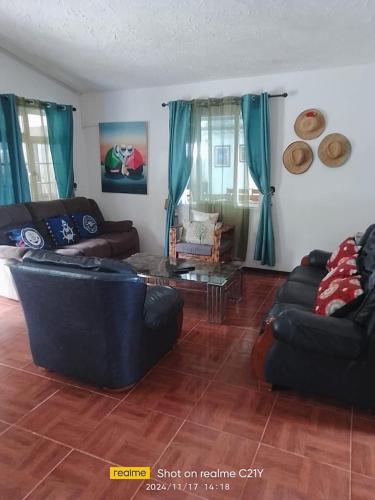 a living room with a couch and a table at Chez Mireille in Tambe
