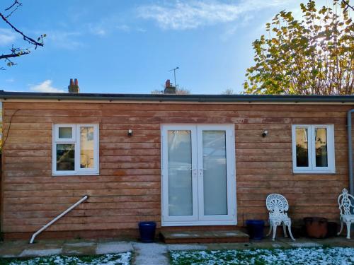a small house with white doors and two chairs at Woodstock Studio in Woodstock