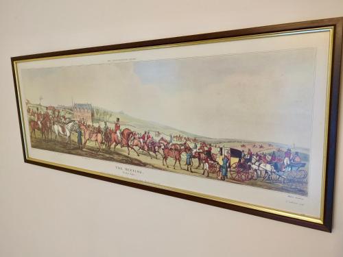 a framed painting of a horse race on a wall at Woodstock Studio in Woodstock