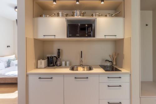 a kitchen with a sink and a microwave at Nemes Apartment The Great - Petite in Nemesvita