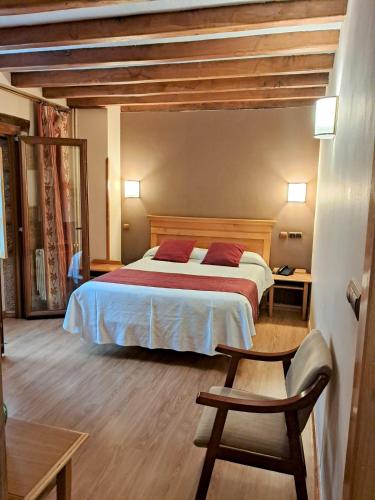 a bedroom with a bed and a chair at Hotel San Roque in Reinosa