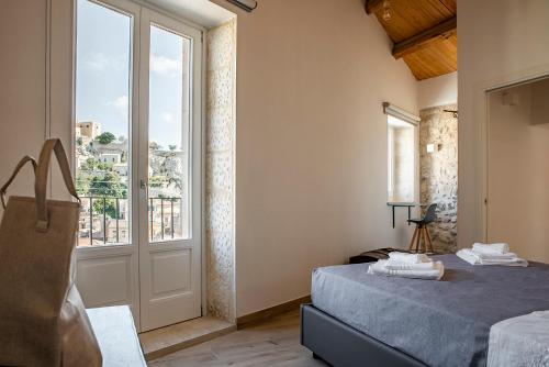 a bedroom with a bed and a large window at Casa Teresa con vista in Modica