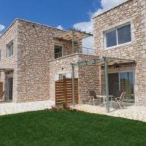a brick house with a table in the yard at Stone Bay Houses in Messinia Kalamaki Beach Area in Chrani