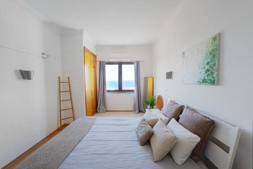 a living room with a couch and a window at Ribeira DIlhas Beach Apartment in Ericeira