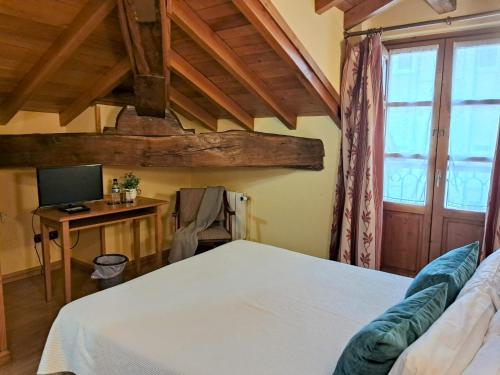 a bedroom with a bed and a desk with a computer at Hotel San Roque in Reinosa