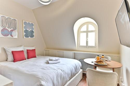 une petite chambre avec un lit et une table dans l'établissement Studio central Opéra Garnier -Paris - II, à Paris