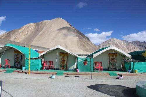 a group of tents with a mountain in the background at Martsemik Camping Spangmik in Chimre