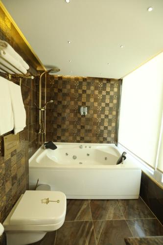 a bathroom with a tub and a toilet in it at Unluselek Hotel in Anamur