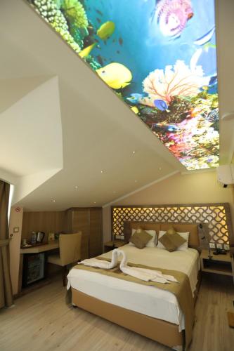 a bedroom with a bed with a large painting on the ceiling at Unluselek Hotel in Anamur