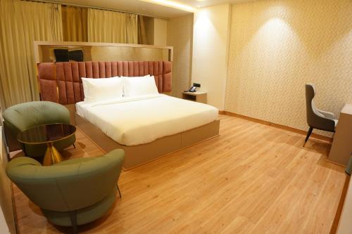 a hotel room with a bed and a chair at The Pearl Petal in Rohtak