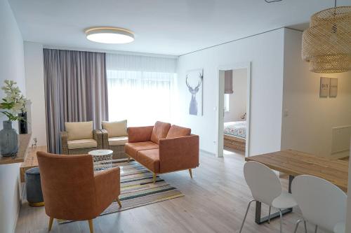 a living room with a couch and a table and chairs at 1.000m Ferienwohnungen in Semmering
