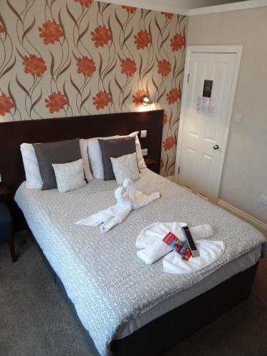 a bed with towels and a stuffed animal on it at Charlotte Guest House in London