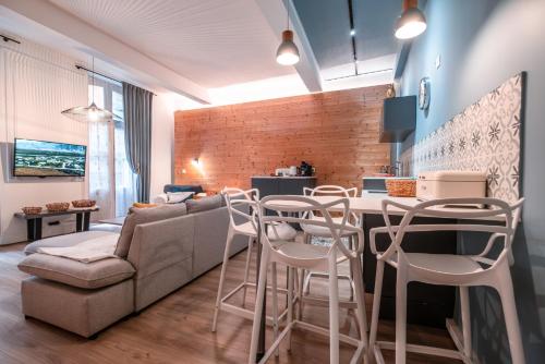 a living room with a couch and a table with stools at Le Duplex Gourmand - Clim et parking - WiFi in Montauban