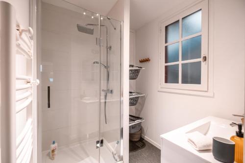 a bathroom with a glass shower and a sink at Le Duplex Gourmand - Clim et parking - WiFi in Montauban