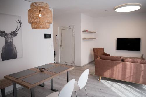 a living room with a couch and a table and chairs at 1.000m Ferienwohnungen in Semmering