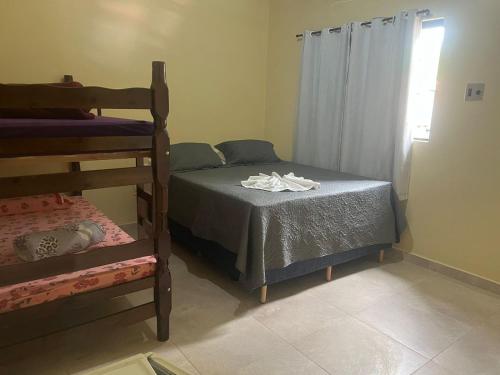a bedroom with two bunk beds and a window at Pousada Beira Rio Barreiras in Barreiras