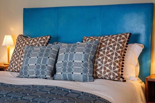 a bed with a blue headboard and pillows on it at The Assembly House in central Norwich in Norwich