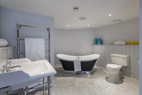 a bathroom with a tub and a toilet and a sink at The Assembly House in central Norwich in Norwich