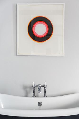 a sink in a bathroom with a picture on the wall at The Assembly House in central Norwich in Norwich