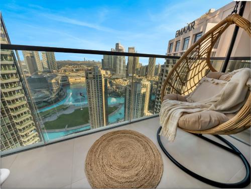 a hammock on a balcony with a view of the city at Wabi-Sabi Style Fountain-View 4 BR Apt in the Sky in Dubai
