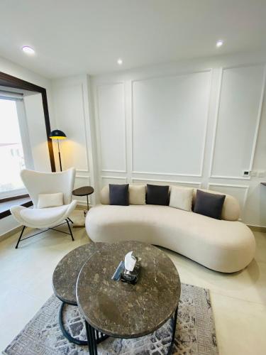 a living room with a white couch and a table at PENTASQUARE Apartments by SUPERHOST STAYS in Lahore