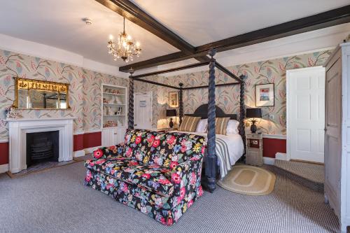 a bedroom with a bed and a couch and a fireplace at The Assembly House in central Norwich in Norwich