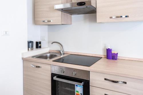 a kitchen with a sink and a stove at MagicHouse 2 Camere 2 Bagni -15 min Colosseo in Rome