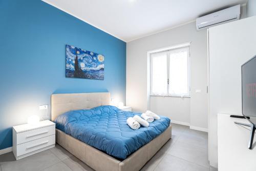 a bedroom with a bed with blue walls and a tv at MagicHouse 2 Camere 2 Bagni -15 min Colosseo in Rome