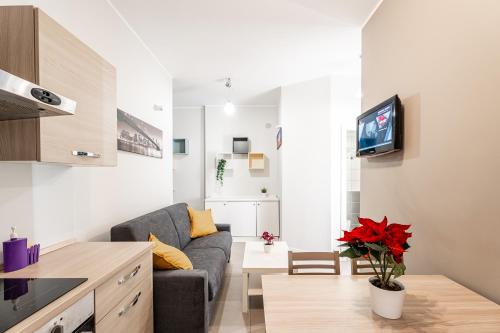 a living room with a gray couch and a kitchen at MagicHouse 2 Camere 2 Bagni -15 min Colosseo in Rome