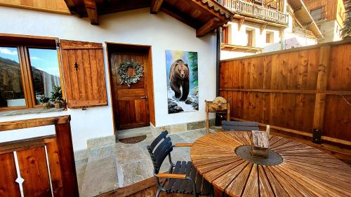 une salle à manger avec une table et une affiche d'ours sur le mur dans l'établissement Chalet Eden Vanoise, à Bourg-Saint-Maurice