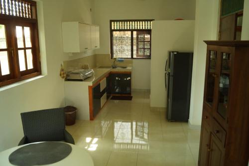 a kitchen with a refrigerator and a table in a room at Gästehaus Isabella in Beruwala
