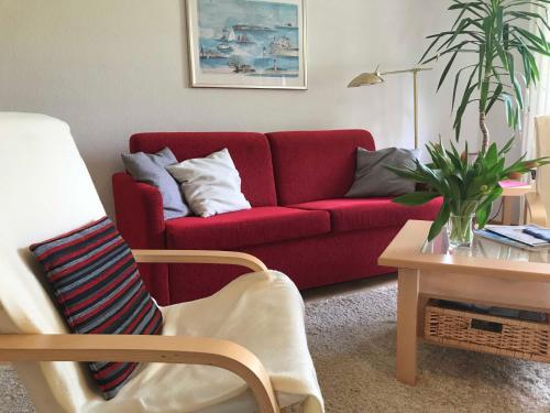 グリュックスブルクにあるFerienwohnung Valentinの赤いソファとテーブルのあるリビングルーム