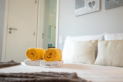 a bedroom with towels on a bed with yellow towels at Solmar Lodge in Ponta Delgada