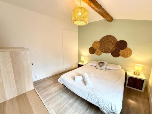 een slaapkamer met een bed en twee nachtkastjes en twee verlichting bij Confort & Cosy Proche centre ville in Valence