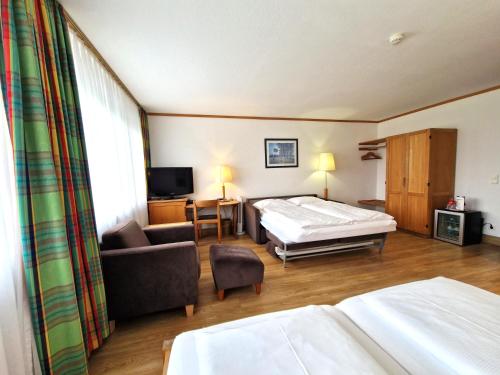 a hotel room with a bed and a couch at Badhotel Restaurant Stauferland in Bad Boll